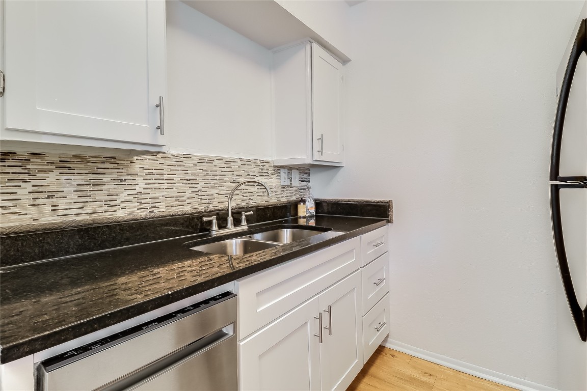 2401 Manor Road, Unit 210 Austin, TX 78722 - Photo 9 of 20 a kitchen with granite countertop white cabinets and a stainless steel appliances