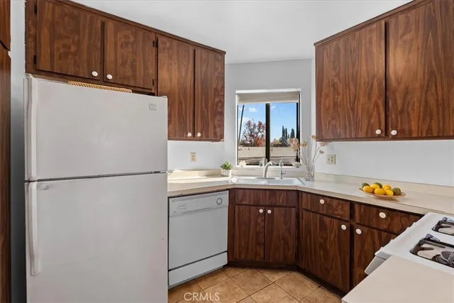 a kitchen with a sink a refrigerator and cabinets
