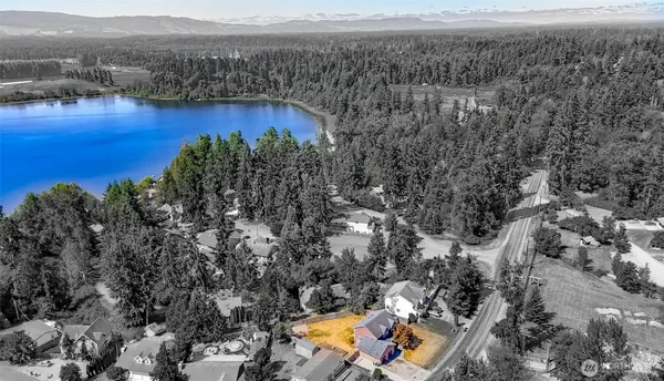 an aerial view of a house with a garden and lake view