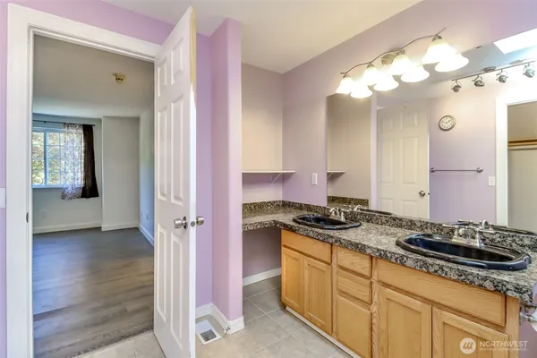 a bathroom with a granite countertop sink a mirror and a shower