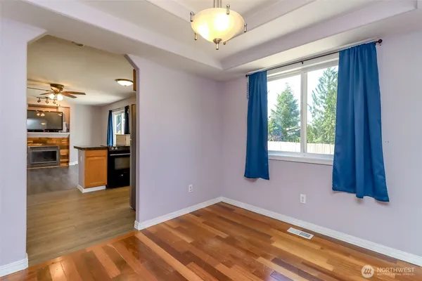 a view of a kitchen with wooden floor and a window