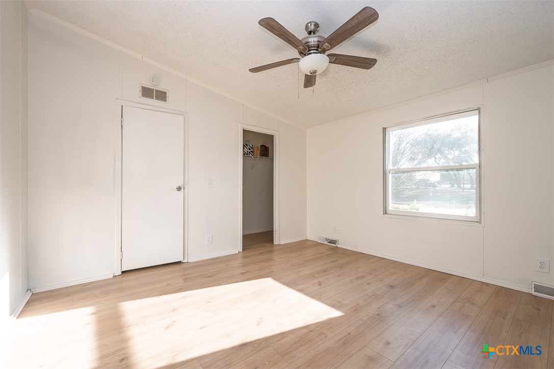 105 Grace Road Belton, TX 76513 - Photo 16 of 25 an empty room with wooden floor ceiling fan and windows
