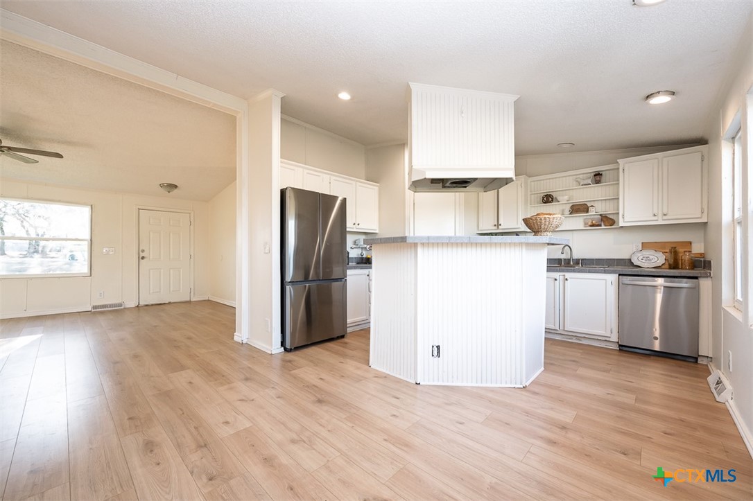 105 Grace Road Belton, TX 76513 - Photo 6 of 25 a kitchen with a refrigerator a stove top oven and wooden floors