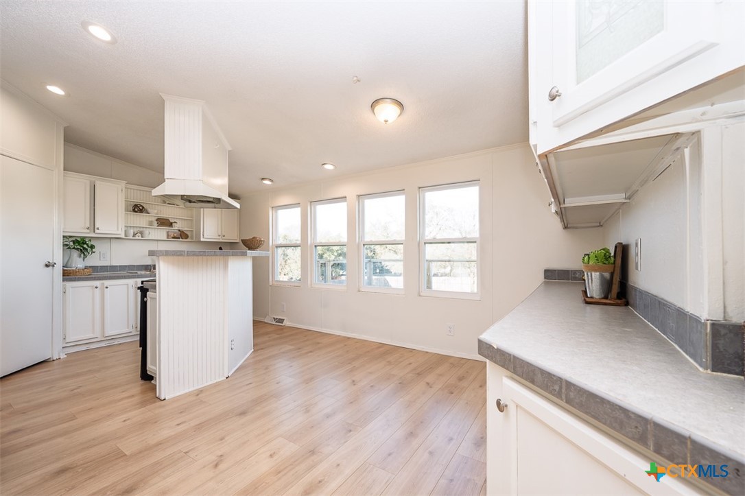 105 Grace Road Belton, TX 76513 - Photo 8 of 25 a kitchen with stainless steel appliances granite countertop a sink stove and white cabinets with wooden floor