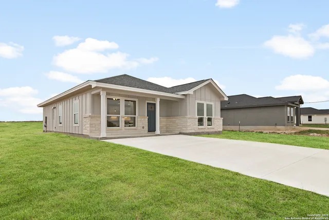 a view of a yard in front of a house with large trees
