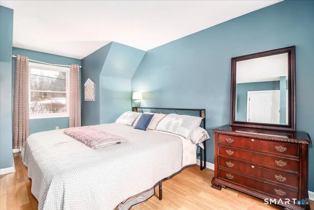 a bedroom with a bed and a mirror on dresser