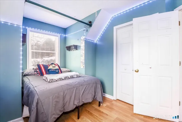 a bedroom with a bed and wooden floor