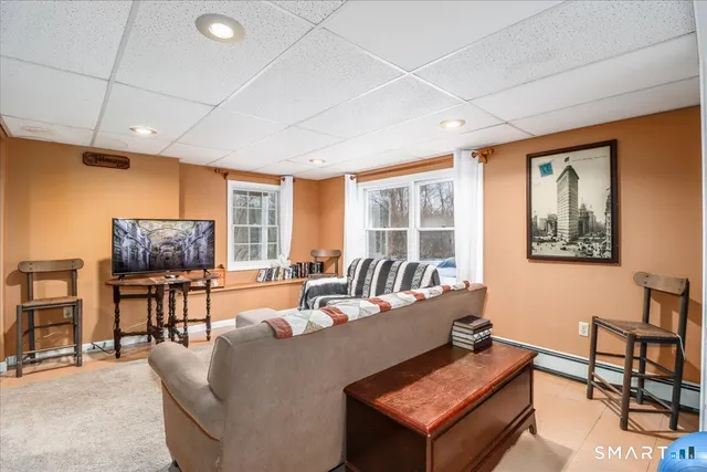 a living room with furniture a flat screen tv and a large window