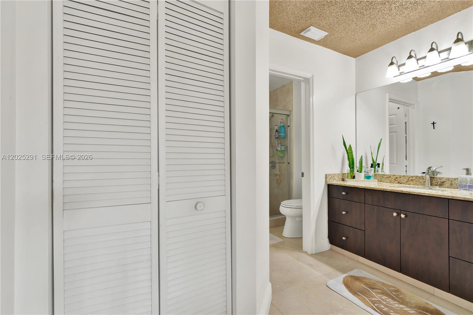 10006 Southwest 162nd Path Miami, FL 33196 - Photo 21 of 40 a spacious bathroom with a double vanity sink a toilet and a mirror