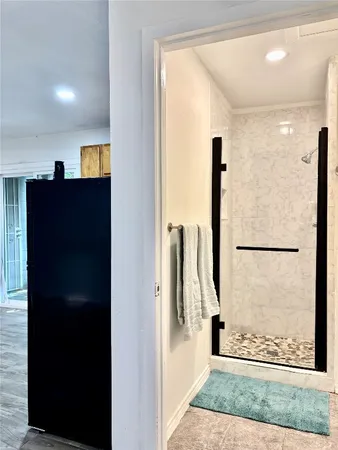 a view of a hallway with wooden floor and a living room