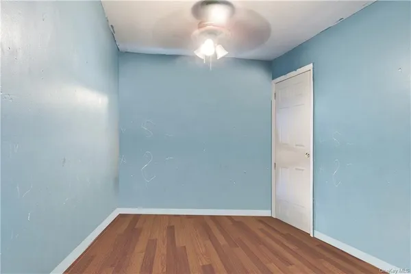 a view of a room with wooden floor and a window