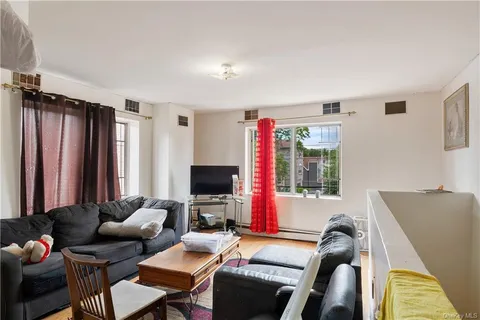 a living room with furniture a flat screen tv and a window