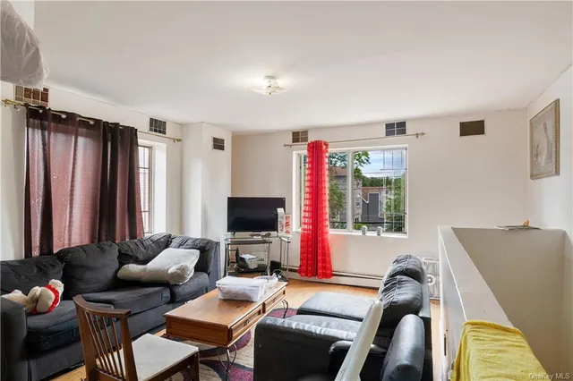 a living room with furniture a flat screen tv and a window