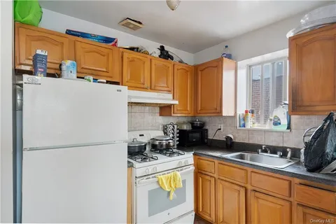 a kitchen with stainless steel appliances granite countertop a refrigerator a sink a stove a microwave and cabinets