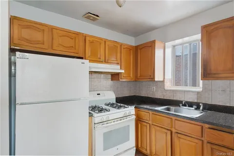 a kitchen with stainless steel appliances granite countertop a refrigerator a stove a sink and cabinets