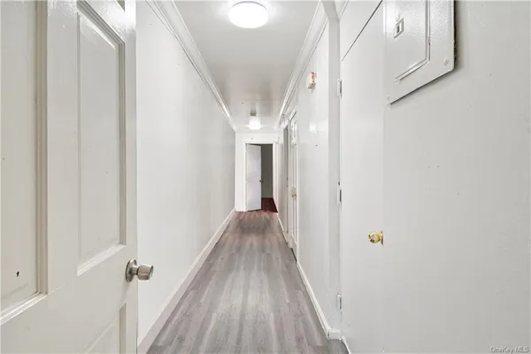 a view of a hallway with wooden floor and staircase