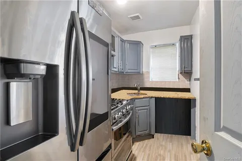 a kitchen with stainless steel appliances granite countertop a refrigerator a sink and a stove