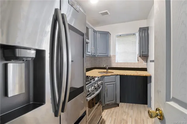 a kitchen with stainless steel appliances granite countertop a refrigerator a sink and a stove