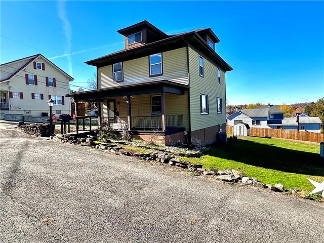 a front view of a house with a yard and porch