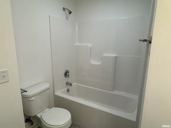 a white toilet and tub sitting next to a bathroom sink
