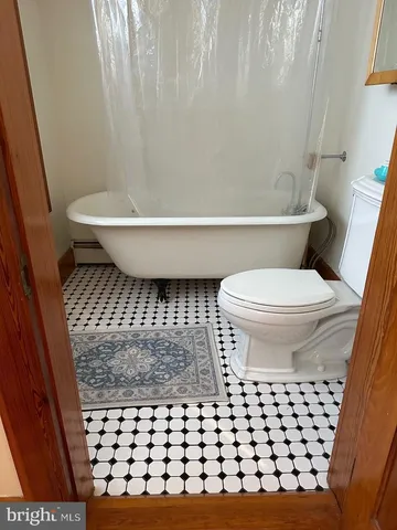 a bathroom with a toilet and a shower curtain