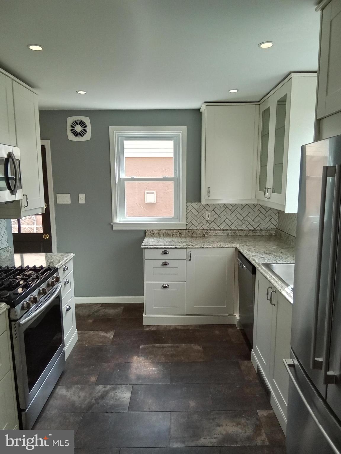 1917 Griffith Street Philadelphia, PA 19111 - Photo 11 of 50 a kitchen with stainless steel appliances granite countertop a stove a sink and a refrigerator