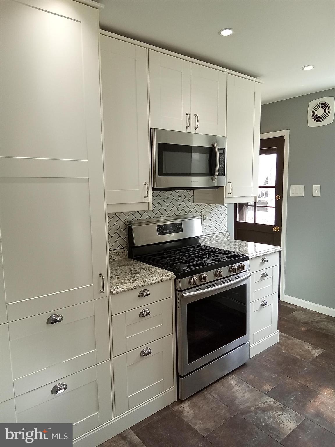1917 Griffith Street Philadelphia, PA 19111 - Photo 14 of 50 a kitchen with stainless steel appliances white cabinets and a stove top oven