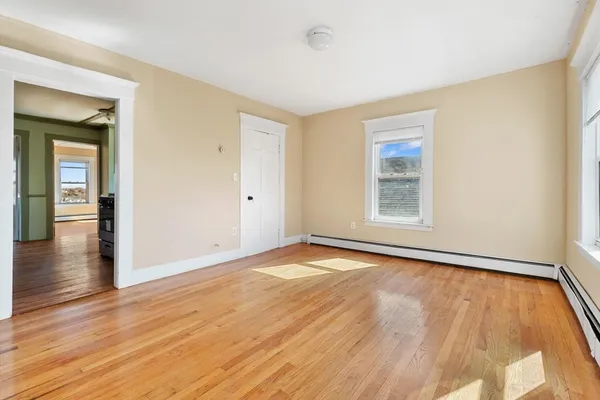 an empty room with wooden floor and windows
