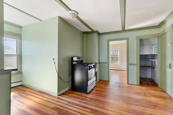 a view of a kitchen with wooden floor and a hallway