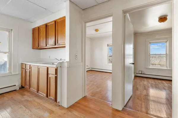 a view of a hallway with wooden floor and a living room