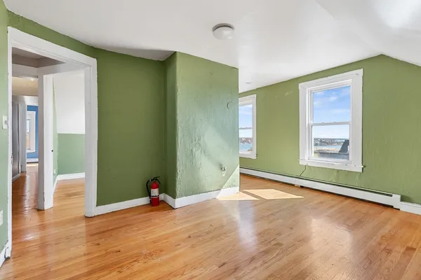 a view of empty room with wooden floor