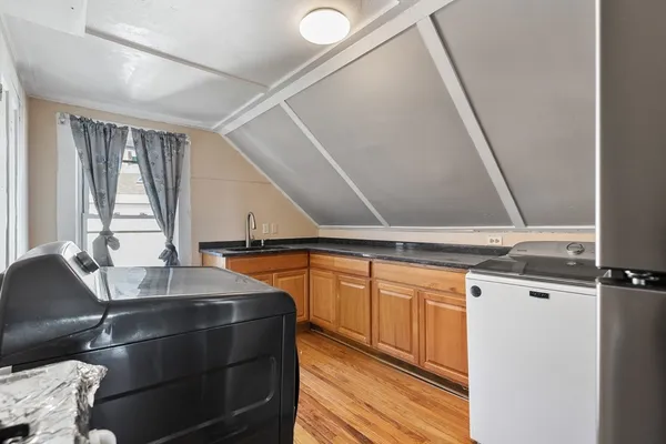 a kitchen with a sink cabinets and wooden floor