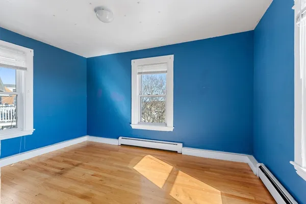 a view of a big room with window and wooden floor