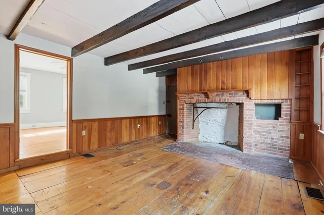 a view of empty room with a fireplace and windows