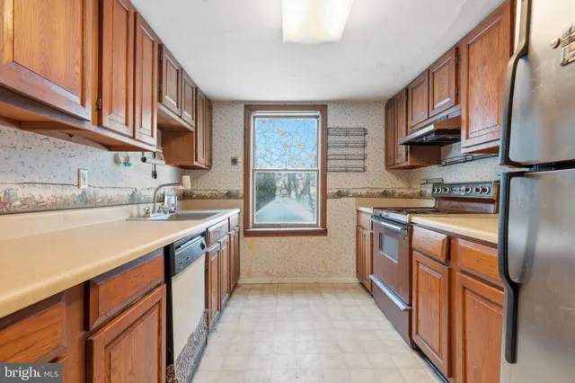 a kitchen with stainless steel appliances granite countertop a refrigerator stove and cabinets