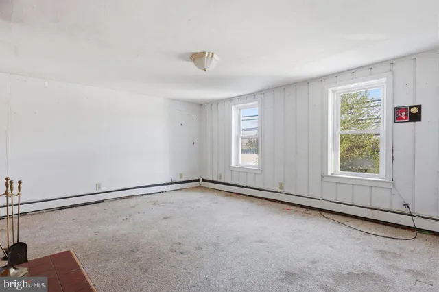 a view of an empty room with a fireplace and a window
