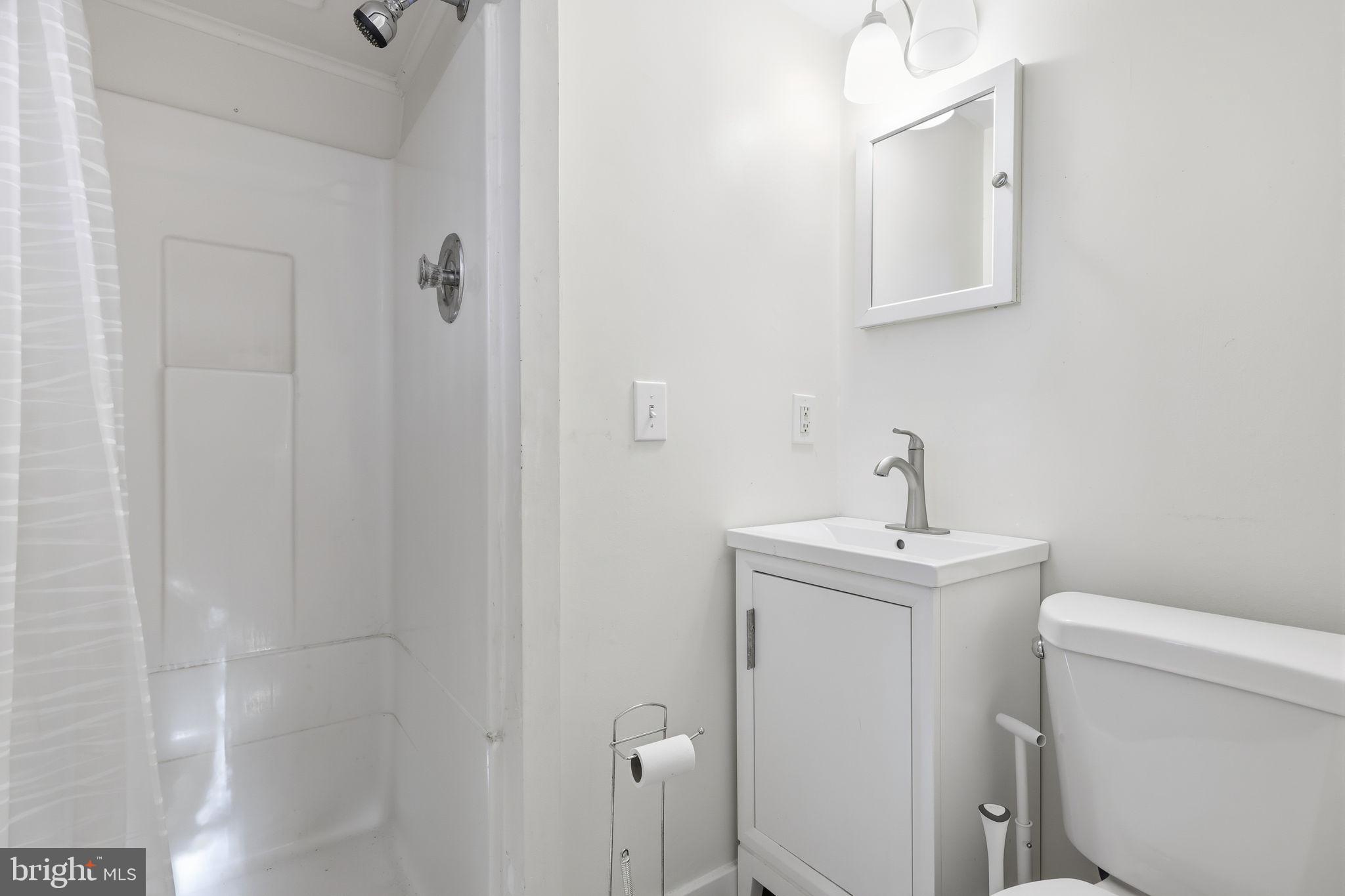 2695 Main Street Lawrence Township, NJ 08648 - Photo 45 of 50 a bathroom with a toilet a sink and mirror
