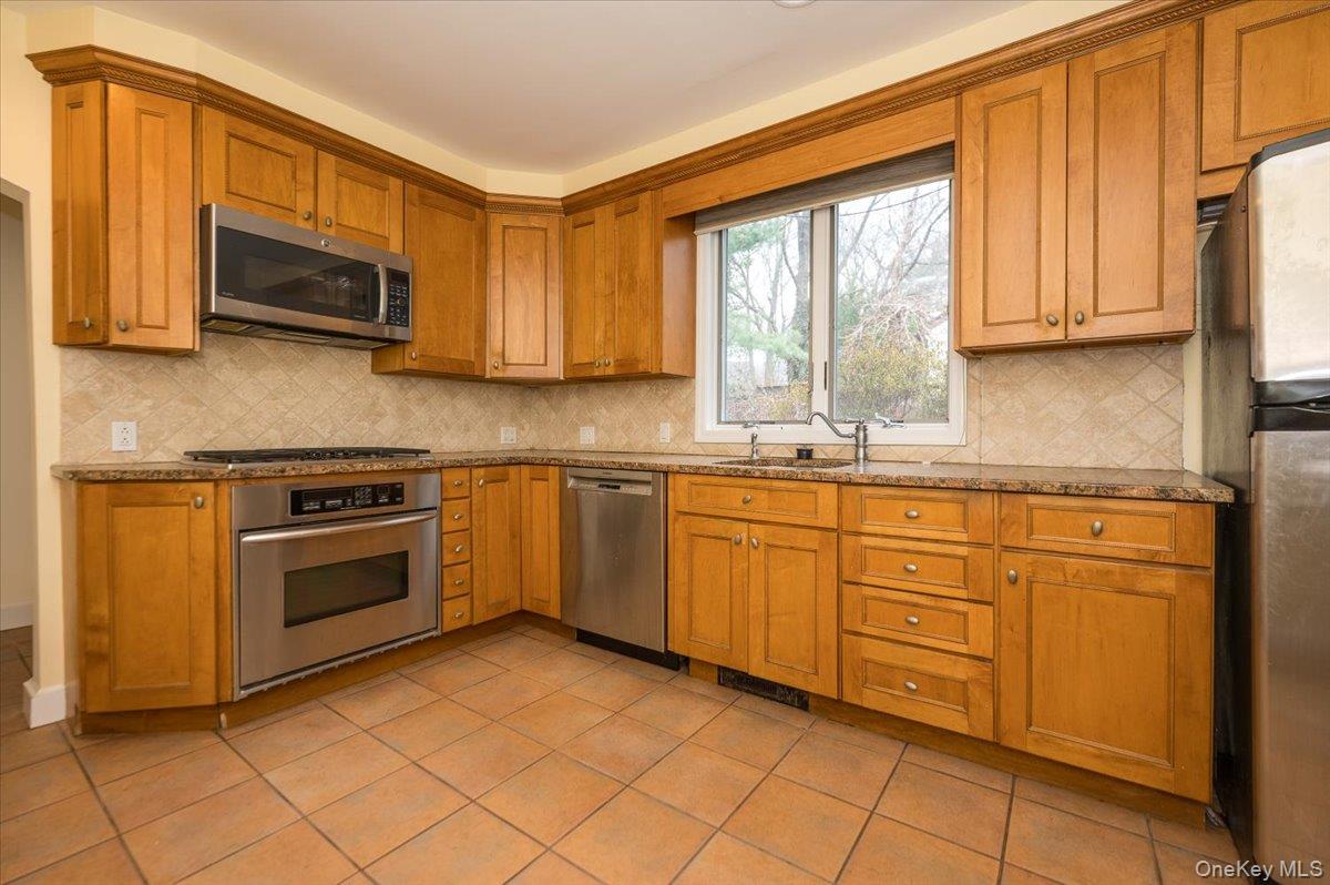 1 Edna Place New Rochelle, NY 10804 - Photo 8 of 24 a kitchen with stainless steel appliances granite countertop a stove a sink and a microwave