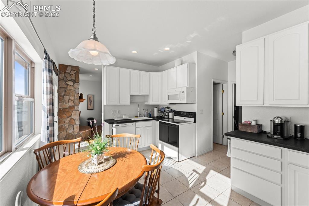 112 Ridge Point Circle Divide, CO 80814 - Photo 33 of 50 a kitchen with stainless steel appliances kitchen island granite countertop a stove a sink a refrigerator and white cabinets