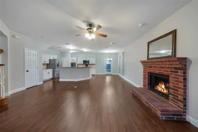 a view of kitchen livingroom with wooden floor and a fireplace