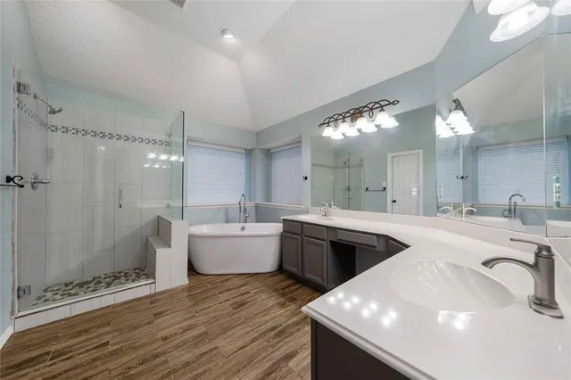 a large white kitchen with a sink and dishwasher a stove with wooden floors