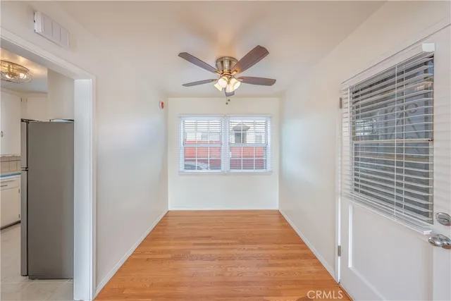 a view of a hallway with a chandelier fan and windows