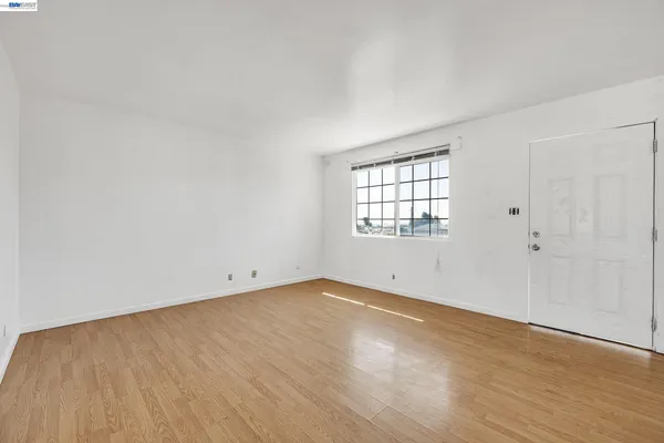 a view of an empty room with wooden floor