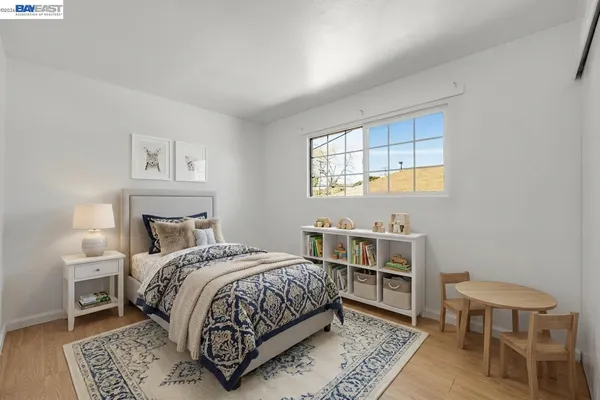 a bedroom with a bed wooden floor and a window