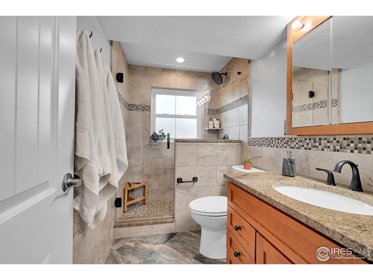 4216 Evans Drive Boulder, CO 80303 - Photo 18 of 26 a bathroom with a granite countertop sink toilet and shower