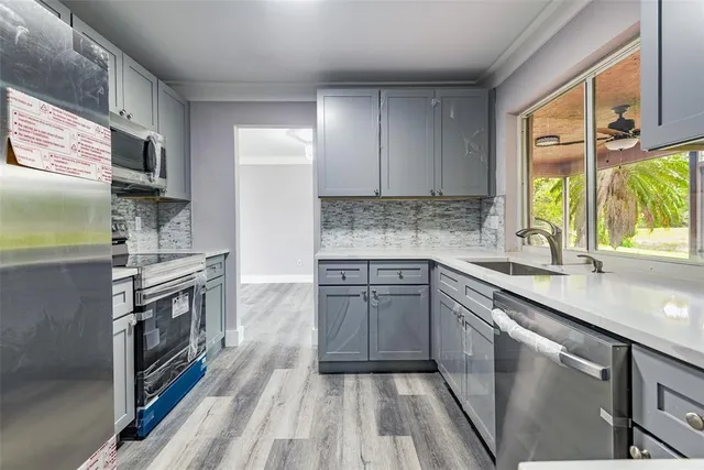 a kitchen with stainless steel appliances granite countertop a stove a sink and a refrigerator