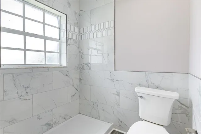 a white toilet sitting next to a bathroom sink