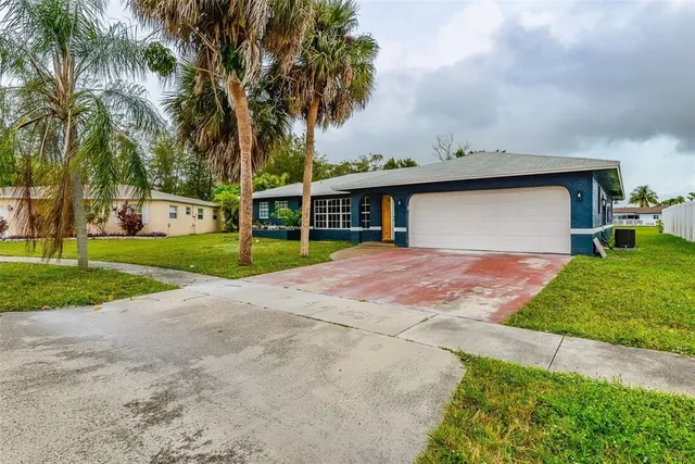a front view of a house with garden and trees