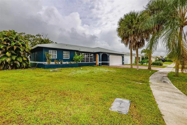 a front view of a house with swimming pool and trees