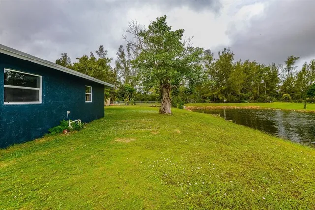 a backyard of a house with lots of green space and fountain